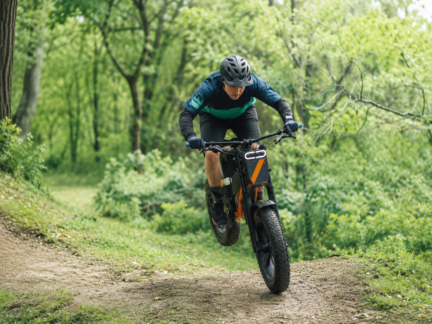 Rijder springt met een elektrische mountainbike op een bospad