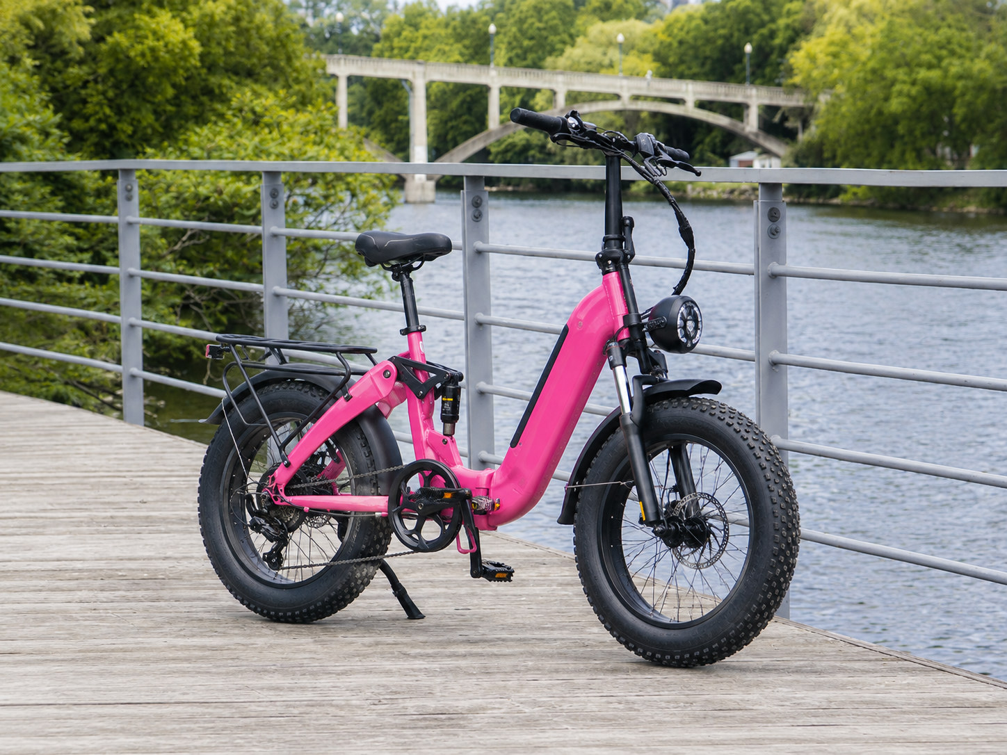 Roze opvouwbare fatbike e-bike op een houten steiger aan de rivier